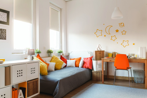 Yellow and orange accessories in modern teen room